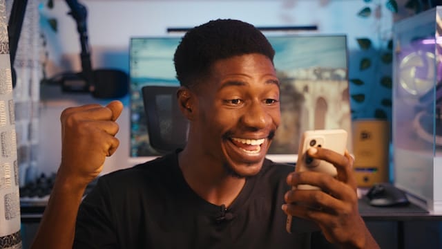 A happy young man sitting at a workstation